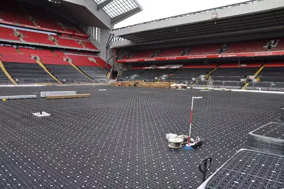 Full-field installation of a shallow geocellular stormwater attenuation system beneath a stadium pitch for rapid drainage and load support.