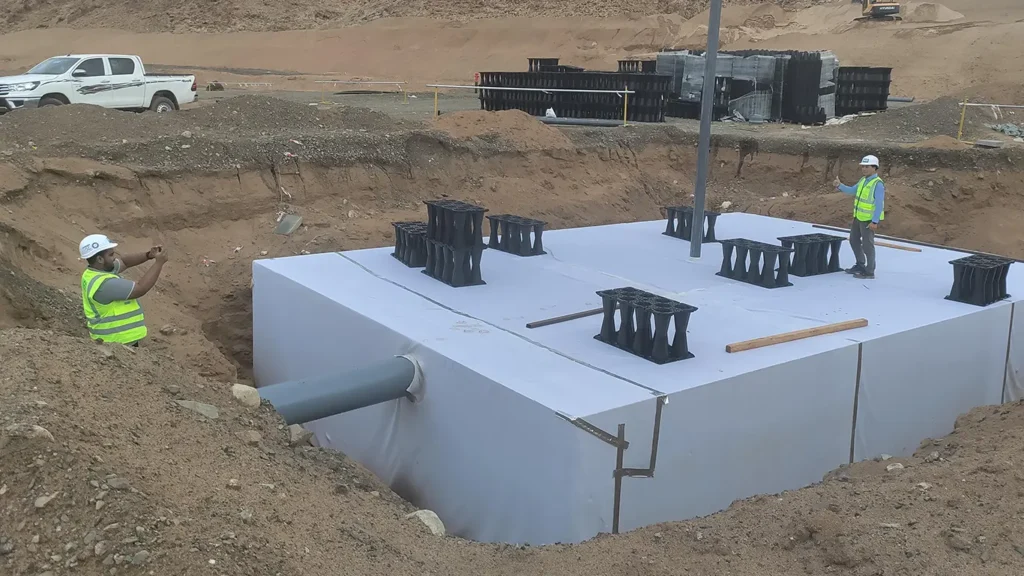 Wrapping stormwater attenuation modules with protective geotextile filter fabric before backfill