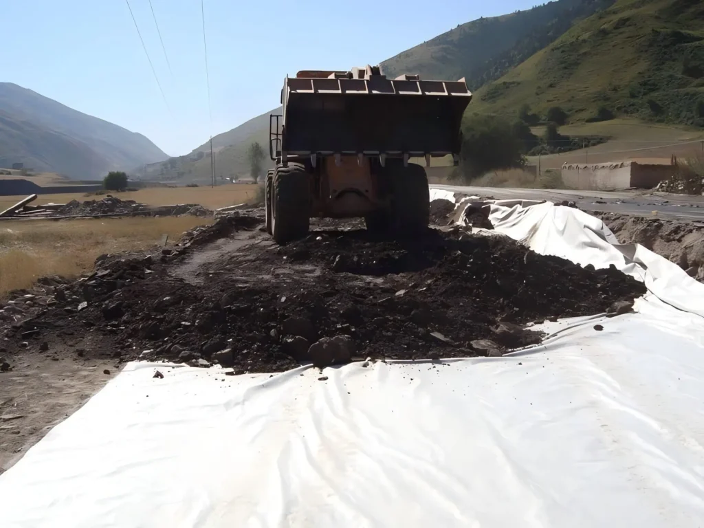 Nonwoven geotextile fabric placed on subgrade for soil separation and road base stabilization