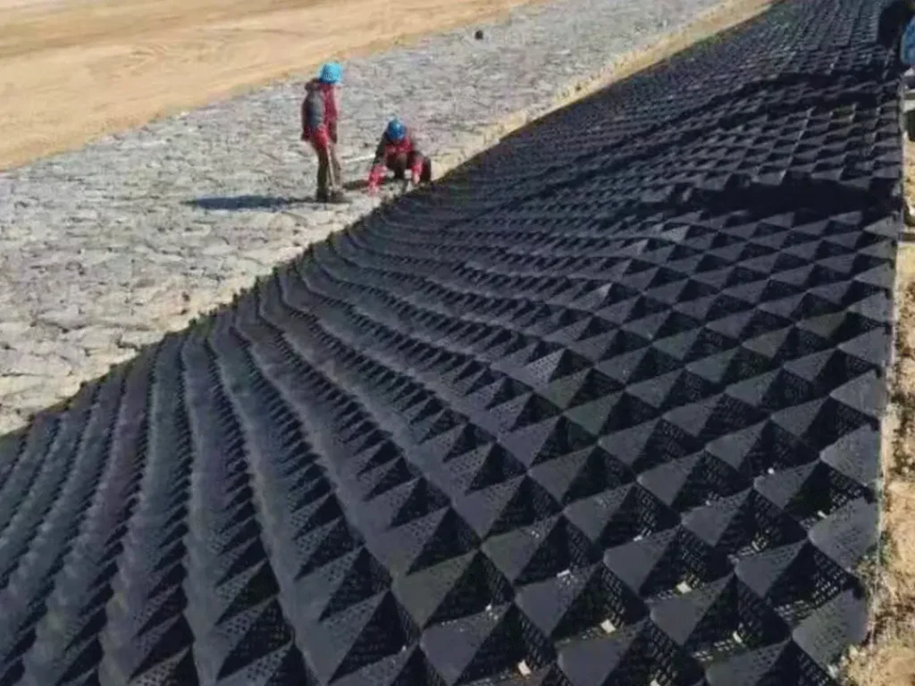 Textured geocell slope protection system installed on steep embankment for erosion control