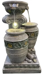 tone fountain installation in a lush green garden setting
