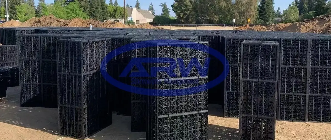 Modular geocellular stormwater detention crates staged for underground installation at a US site — plastic modules for infiltration and peak-flow attenuation.