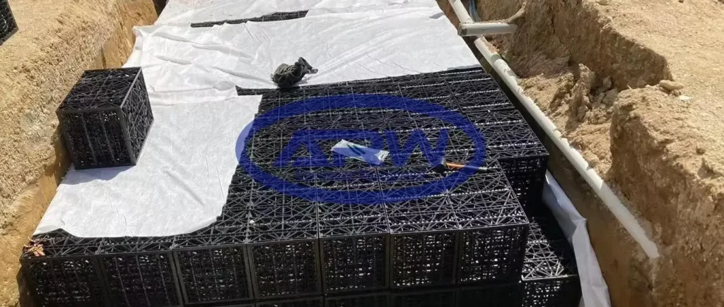 ANZ residential OSD system—geocellular crates laid on white nonwoven geotextile; side pipes connect the bed for attenuation and infiltration.